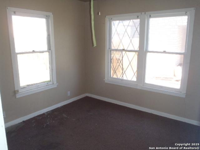 unfurnished room featuring carpet floors, plenty of natural light, and baseboards