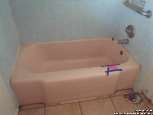 full bath with a tub to relax in and tile patterned flooring