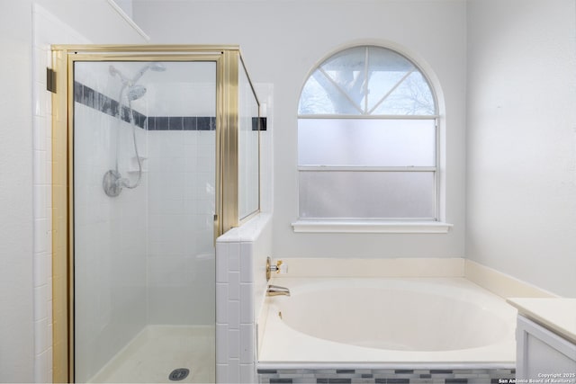 bathroom featuring a garden tub, a shower stall, and vanity