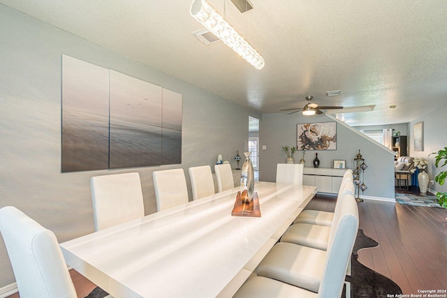 dining room with a ceiling fan, visible vents, dark wood finished floors, and a textured ceiling