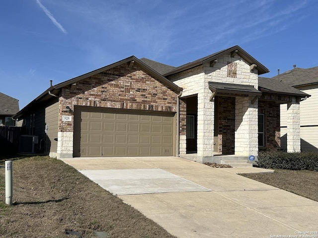 french provincial home featuring concrete driveway, roof with shingles, an attached garage, and central air condition unit