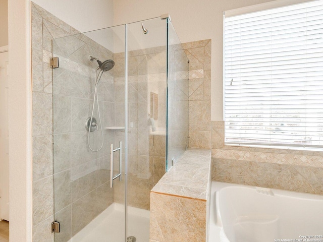 bathroom featuring a stall shower and a garden tub