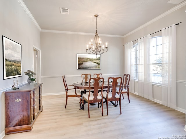 dining space featuring crown molding, light wood-style flooring, visible vents, and an inviting chandelier