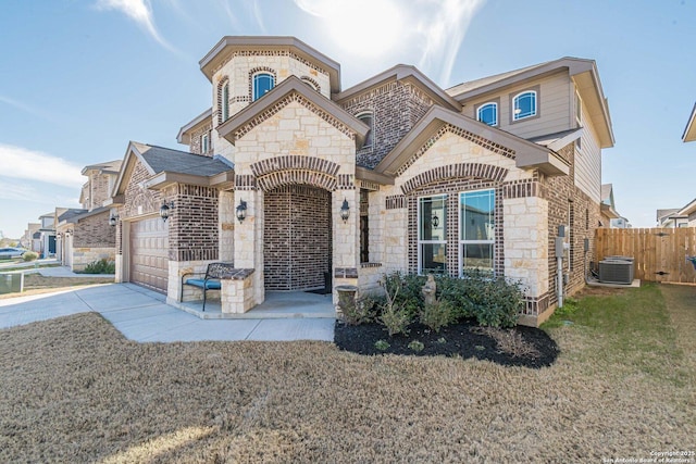 view of front of home featuring an attached garage, brick siding, fence, concrete driveway, and stone siding