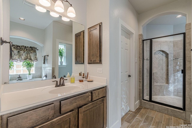 bathroom featuring a stall shower, wood tiled floor, visible vents, and vanity