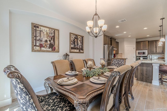 dining room with recessed lighting, visible vents, an inviting chandelier, light wood-style floors, and baseboards