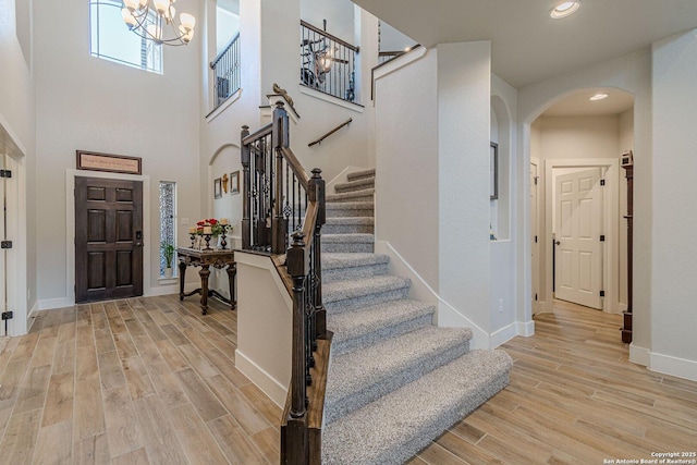 entrance foyer with light wood-style floors, baseboards, arched walkways, and recessed lighting