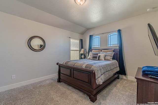 bedroom with lofted ceiling, light colored carpet, a textured ceiling, and baseboards