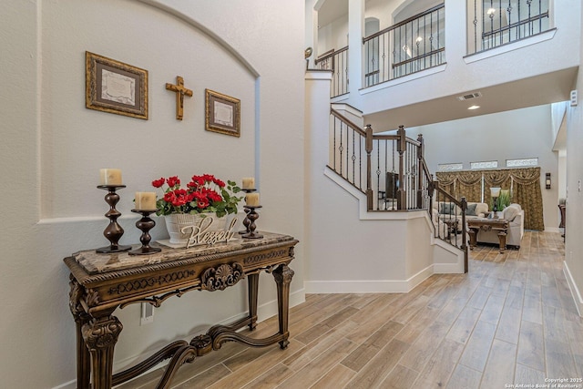 interior space featuring visible vents, stairway, baseboards, and wood finished floors