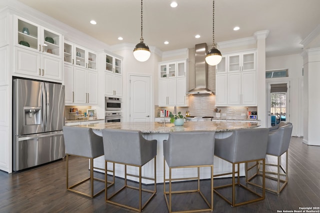 kitchen featuring stainless steel appliances, a spacious island, white cabinetry, and wall chimney exhaust hood