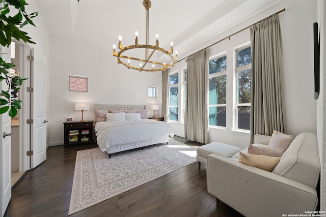 bedroom featuring dark wood-style floors, a tray ceiling, baseboards, and an inviting chandelier