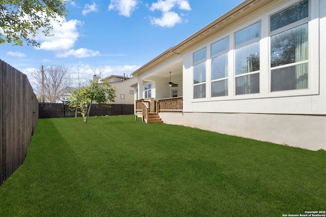 view of yard featuring ceiling fan and a fenced backyard