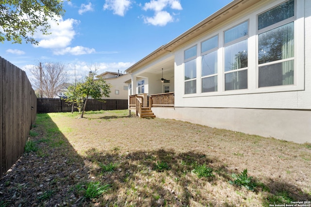 view of yard with a fenced backyard and a ceiling fan