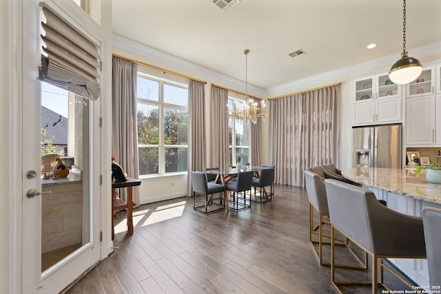 dining space featuring ornamental molding, visible vents, dark wood finished floors, and an inviting chandelier