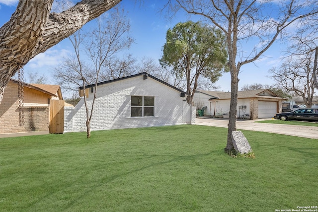 mid-century inspired home featuring driveway, brick siding, a front yard, and fence