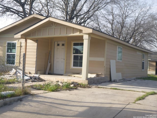 bungalow featuring covered porch and concrete driveway