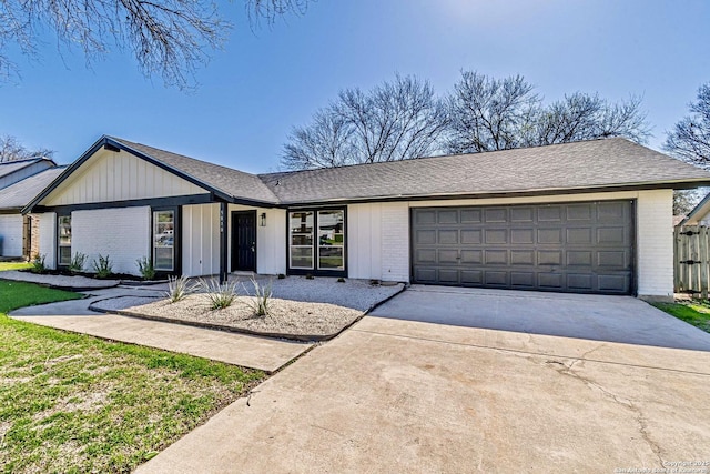 view of front facade featuring a garage, driveway, brick siding, and roof with shingles