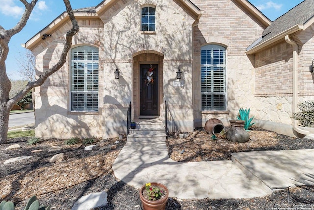 view of exterior entry with brick siding