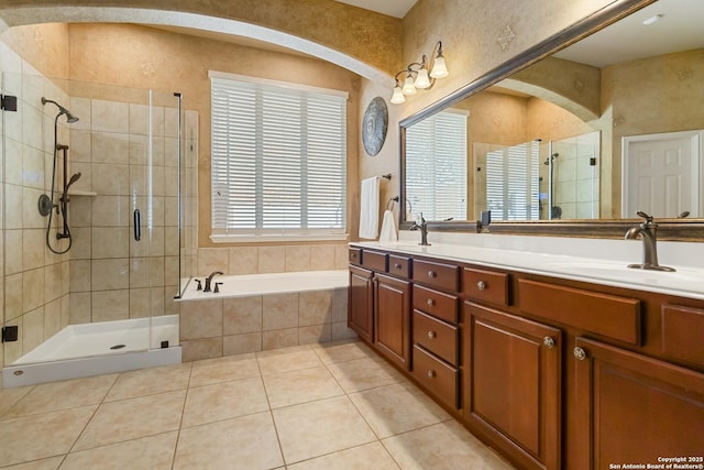 full bathroom featuring a garden tub, a shower stall, a sink, and tile patterned floors