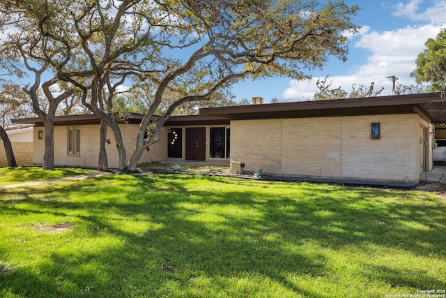 back of property with brick siding and a lawn