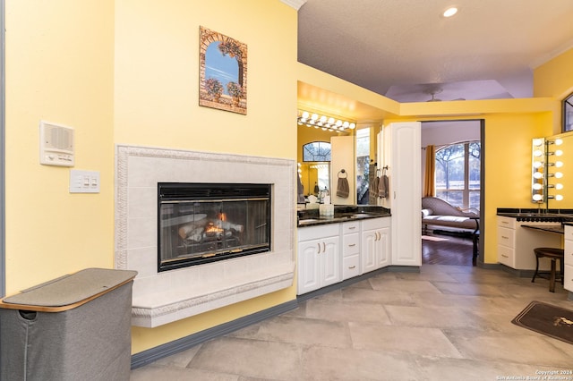 interior space with a glass covered fireplace, vanity, and recessed lighting