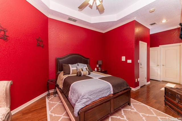 bedroom with baseboards, visible vents, and wood finished floors