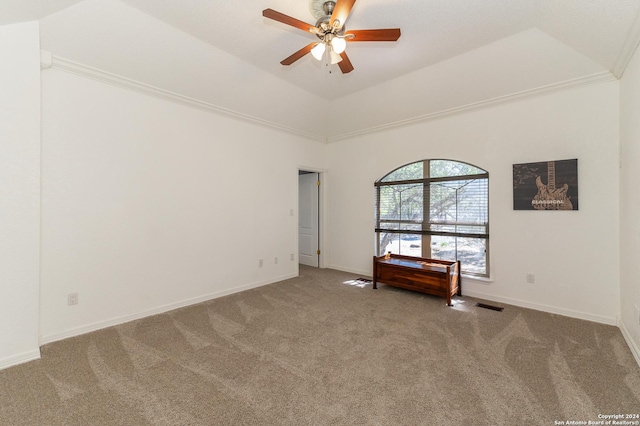 carpeted spare room with lofted ceiling, ceiling fan, visible vents, and baseboards