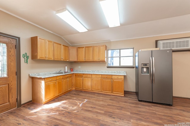 kitchen featuring lofted ceiling, a wall mounted AC, a sink, wood finished floors, and stainless steel fridge with ice dispenser