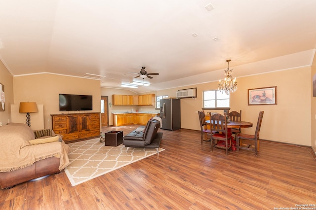 living room with ceiling fan with notable chandelier, light wood-type flooring, ornamental molding, and a wall mounted AC