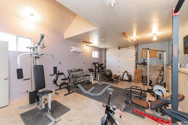 workout room featuring a garage and a wall mounted air conditioner