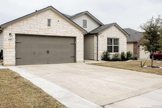 view of front facade featuring a garage, driveway, and a shingled roof