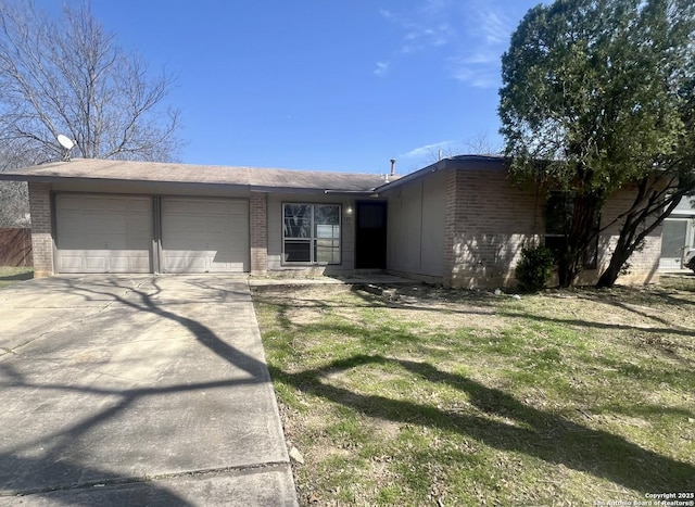 single story home with a garage, a front yard, concrete driveway, and brick siding