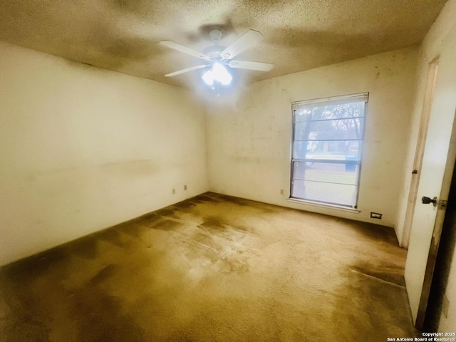 empty room with a textured ceiling, a ceiling fan, and carpet flooring