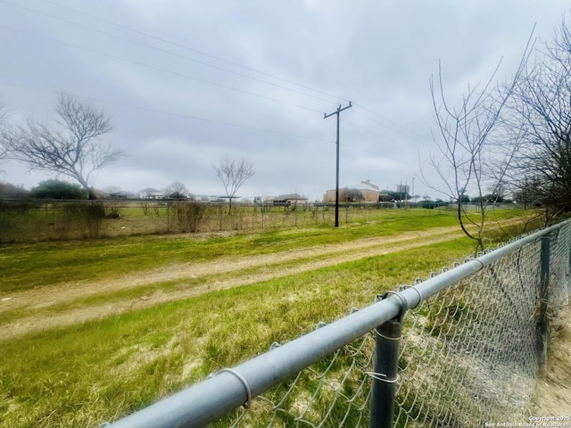 view of yard featuring a rural view and fence