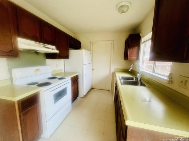 kitchen featuring under cabinet range hood, white appliances, a sink, and light countertops