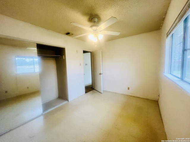 unfurnished bedroom featuring a ceiling fan, a closet, visible vents, and a textured ceiling