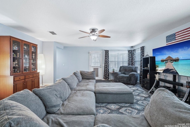 living area with ceiling fan, a textured ceiling, and visible vents