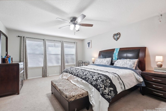 carpeted bedroom featuring ceiling fan, a textured ceiling, and baseboards