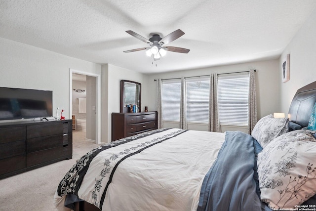 bedroom featuring a textured ceiling, ceiling fan, carpet flooring, and connected bathroom