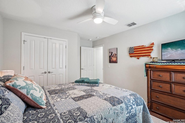 bedroom with ceiling fan, visible vents, and a closet