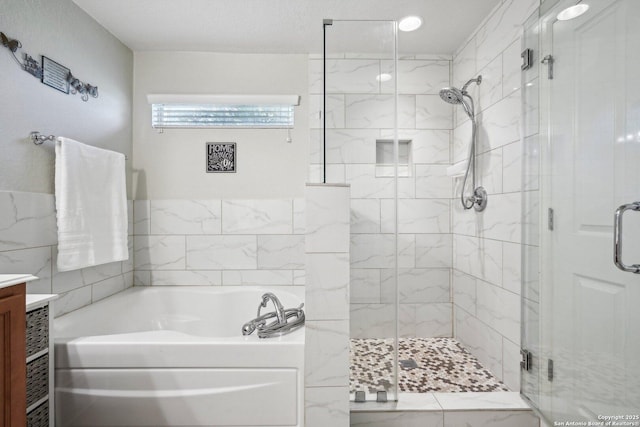 bathroom featuring a shower stall, a bath, and vanity