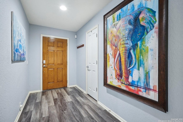 interior space featuring baseboards and wood finished floors