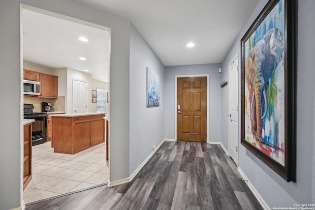 interior space with light wood finished floors, baseboards, and recessed lighting