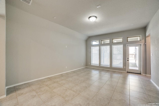 unfurnished room featuring lofted ceiling, light tile patterned floors, baseboards, and visible vents