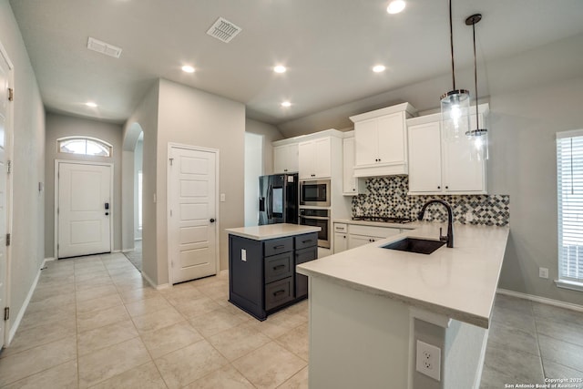 kitchen featuring visible vents, light countertops, appliances with stainless steel finishes, white cabinetry, and a sink