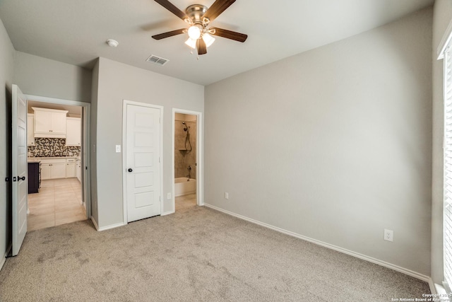 unfurnished bedroom with connected bathroom, baseboards, visible vents, and light carpet