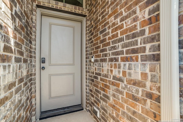 property entrance featuring brick siding