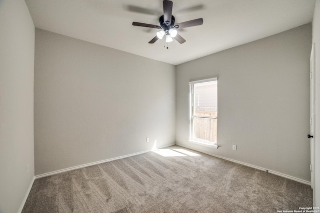 carpeted empty room featuring ceiling fan and baseboards