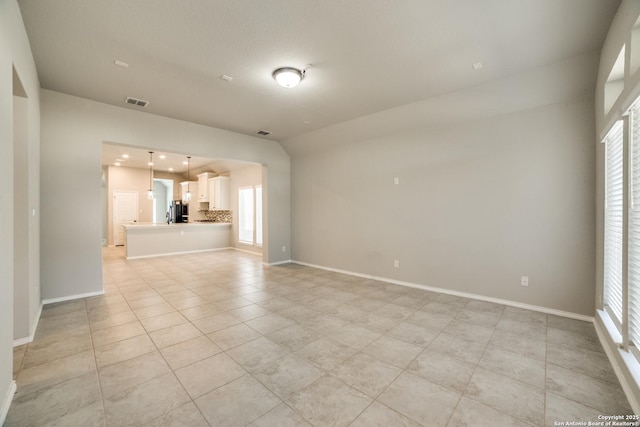 empty room featuring a wealth of natural light and baseboards