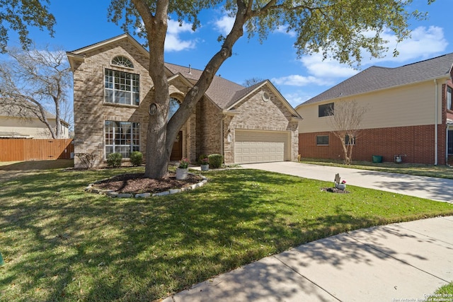 traditional home with a front yard, fence, concrete driveway, and brick siding